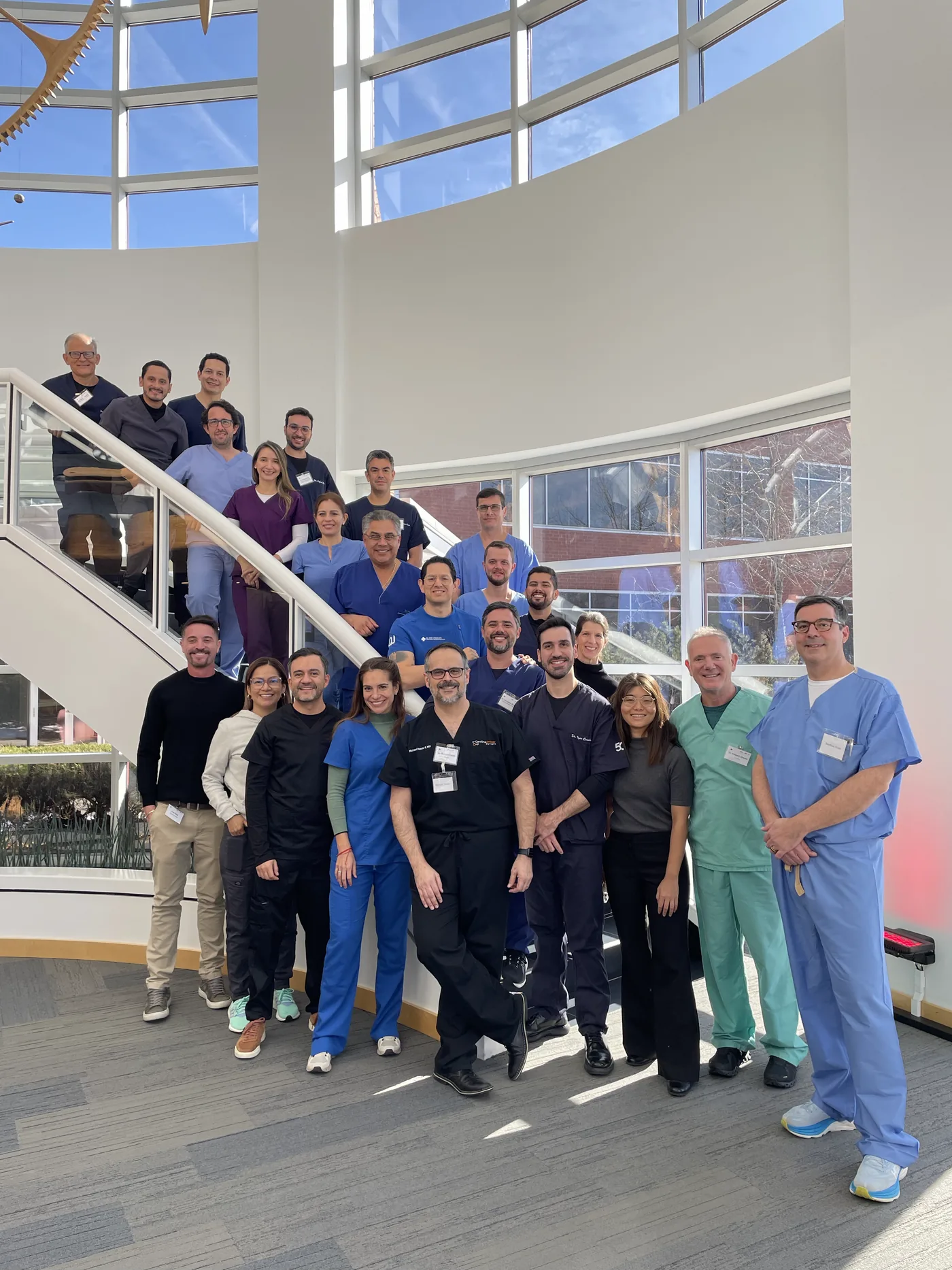 Attending urologists and faculty from an IPP Surgical Masterclass course, photographed together on the stairs